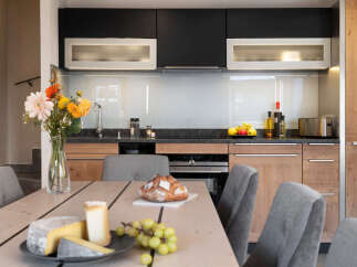 This stunning kitchen boasts modern dark and light wood cabinetry, sleek countertops, and integrated appliances.