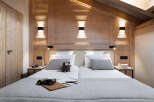 Cozy chalet bedroom with wooden walls and a comfortable double bed.