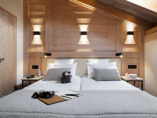 Cozy chalet bedroom with wooden walls and a comfortable double bed.