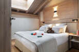 Cozy chalet bedroom with a double bed, plush bedding, and wooden accents.