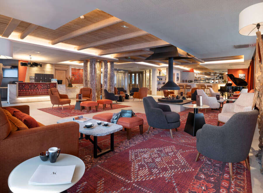 The hotel lobby boasts a stunning design with a blend of modern and traditional elements, featuring a cozy fireplace as a centerpiece.