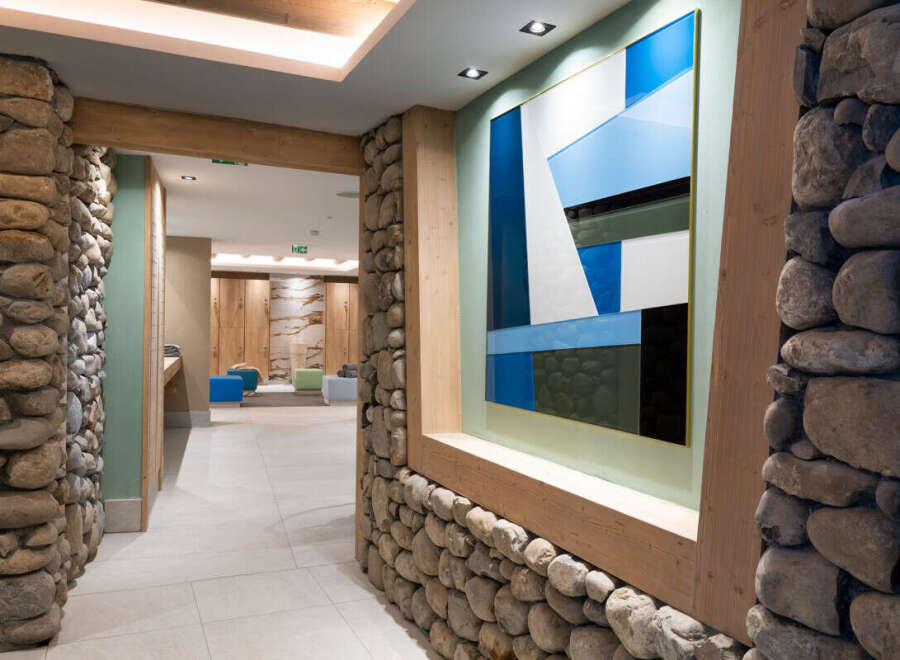 This stunning hallway features a unique blend of natural stone and modern art, creating a welcoming and sophisticated atmosphere.