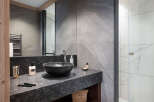 This luxurious bathroom boasts a sleek, modern design with dark granite countertops and a stylish black sink.