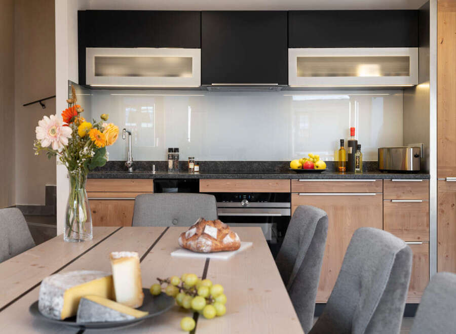This stunning kitchen boasts modern dark and light wood cabinetry, sleek countertops, and integrated appliances.