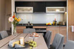 This stunning kitchen boasts modern dark and light wood cabinetry, sleek countertops, and integrated appliances.