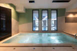 Indulge in tranquility at our luxurious spa, featuring a soothing jacuzzi with views of a serene indoor pool.