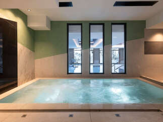 Indulge in tranquility at our luxurious spa, featuring a soothing jacuzzi with views of a serene indoor pool.