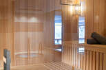 Relax and rejuvenate in our luxurious sauna, featuring light wood paneling, comfortable benches, and a calming atmosphere.