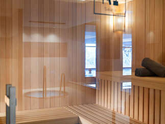 Relax and rejuvenate in our luxurious sauna, featuring light wood paneling, comfortable benches, and a calming atmosphere.