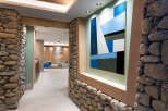 This stunning hallway features a unique blend of natural stone and modern art, creating a welcoming and sophisticated atmosphere.