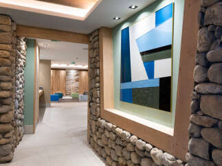 This stunning hallway features a unique blend of natural stone and modern art, creating a welcoming and sophisticated atmosphere.