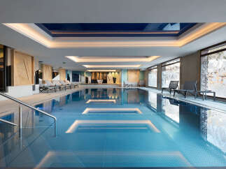Indulge in the serene atmosphere of our indoor pool, featuring a sleek design and floor-to-ceiling windows offering stunning views.