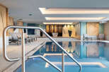 Indulge in the serene atmosphere of our indoor pool, featuring a sleek, modern design and calming color palette.