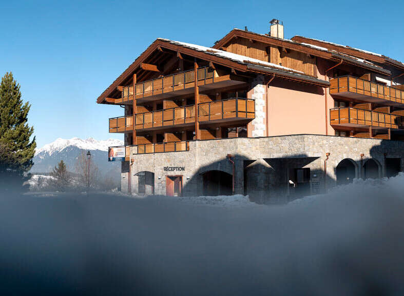 This stunning chalet-style hotel boasts multiple floors with private balconies, offering breathtaking mountain views.