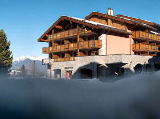 This stunning chalet-style hotel boasts multiple floors with private balconies, offering breathtaking mountain views.