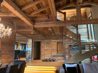 This stunning chalet boasts a magnificent open-plan living area with exposed wooden beams and a breathtaking wooden staircase.
