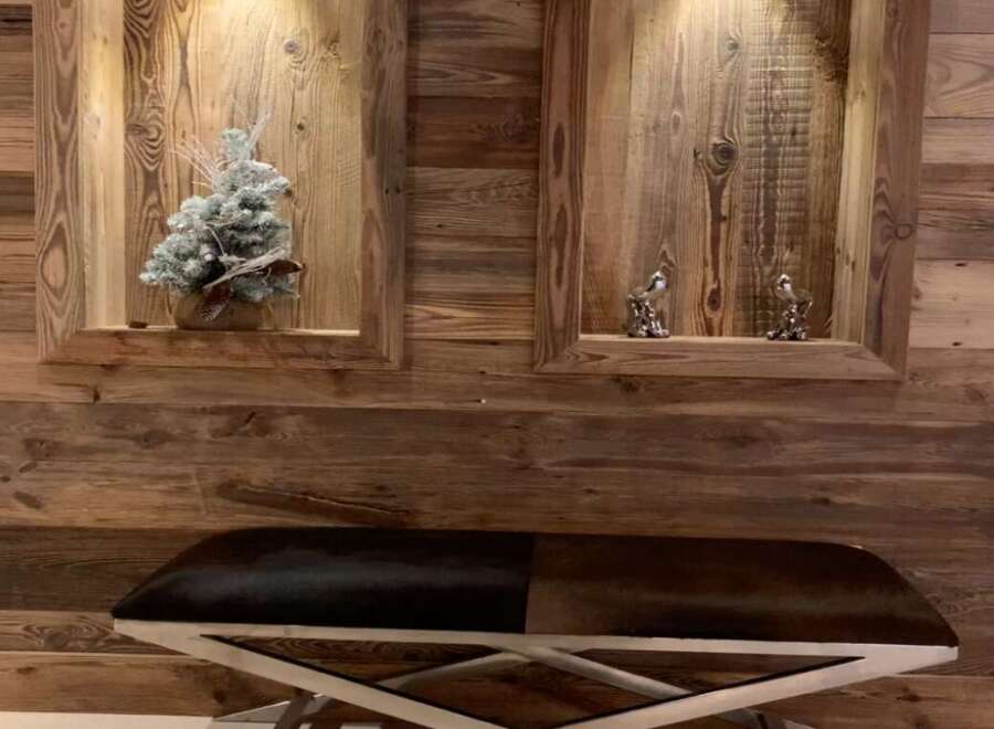 This stunning property boasts a unique wooden wall feature with built-in shelving, adding character and warmth to the space.