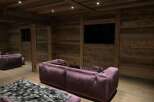 Luxurious chalet home theater with stunning reclaimed wood walls and plush velvet seating.