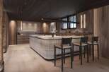 This stunning kitchen boasts a modern design with a rustic touch, featuring a large island with bar seating and sleek cabinetry.