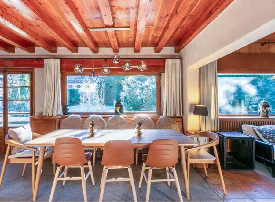 This stunning chalet boasts a spacious dining area with a large wooden table and comfortable seating, perfect for family gatherings.