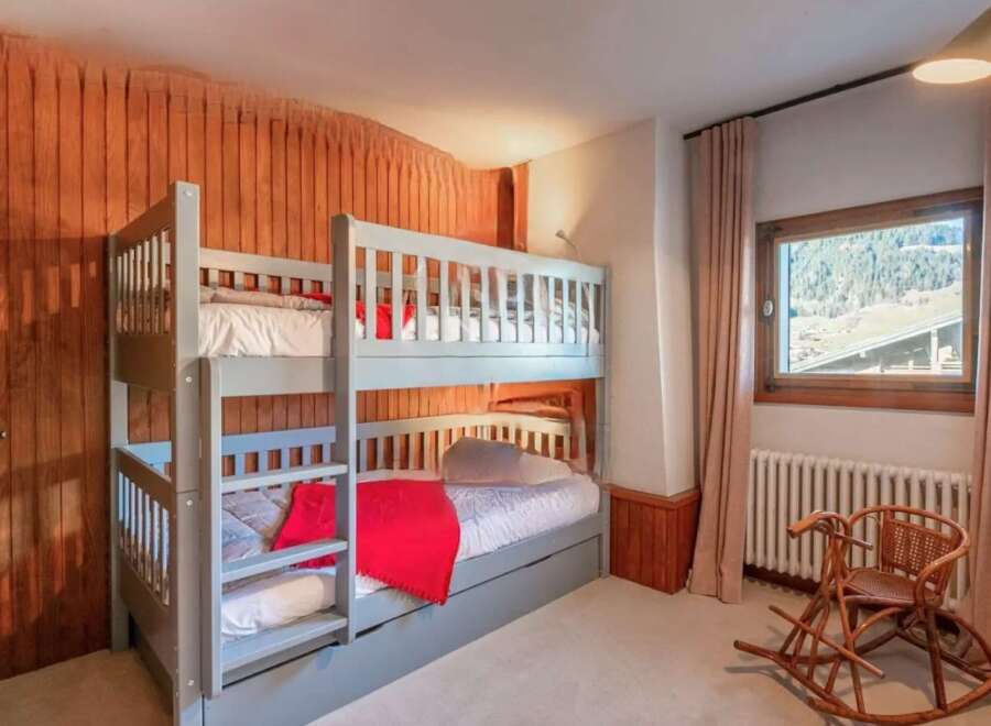 Cozy chalet bedroom with a built-in bunk bed, perfect for families.