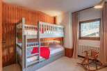 Cozy chalet bedroom with a built-in bunk bed, perfect for families.