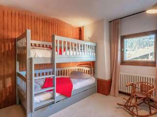 Cozy chalet bedroom with a built-in bunk bed, perfect for families.