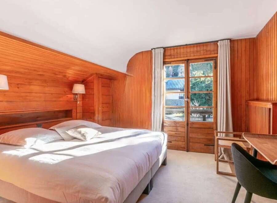 Wake up to stunning views from this chalet bedroom, featuring a comfortable king-size bed and large windows.