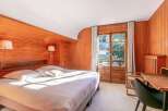 Wake up to stunning views from this chalet bedroom, featuring a comfortable king-size bed and large windows.