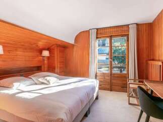 Wake up to stunning views from this chalet bedroom, featuring a comfortable king-size bed and large windows.
