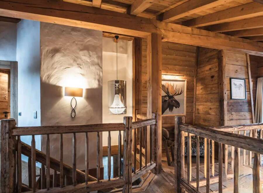 Rustic-chic chalet with exposed wooden beams and a stunning chandelier.