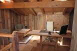 Rustic wooden office space with exposed beams and reclaimed wood walls.