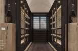 This luxurious wine cellar boasts a lime ceiling, glass door, and wide-slat parquet flooring.