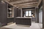 This stunning kitchen boasts a dark wood and grey stone bar, a central island, and integrated lighting.