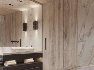 Luxurious master bathroom boasts marble bathtub, wide stone basin, and dark wood cabinetry.