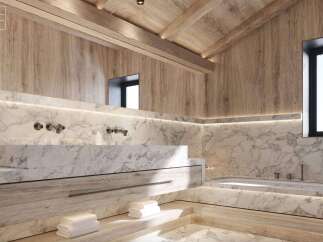 Luxurious bathroom with marble bathtub and basin, light wood cabinetry, and integrated lighting.