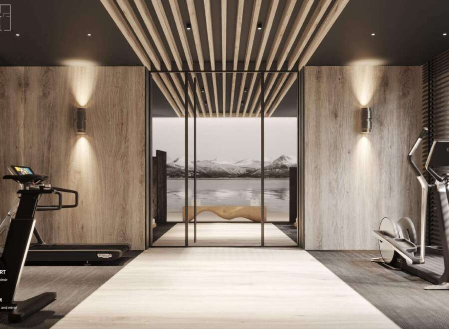 Luxury fitness room with integrated lighting, light wood walls and mirror, and dark wood ceiling.