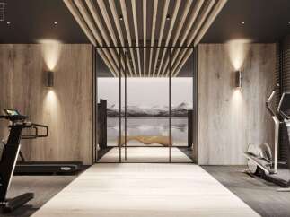 Luxury fitness room with integrated lighting, light wood walls and mirror, and dark wood ceiling.