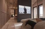 Luxury chalet bedroom with stunning mountain views and a built-in TV showcasing a James Bond movie.