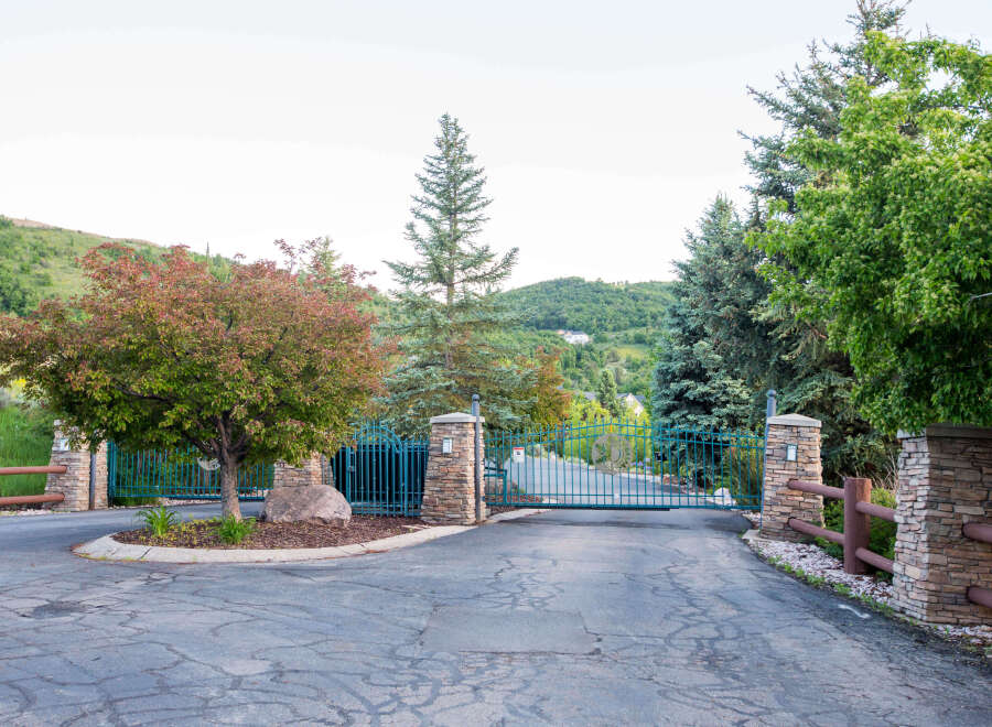 Discover the charm of this gated community entrance, featuring a beautiful teal gate and stone pillars.