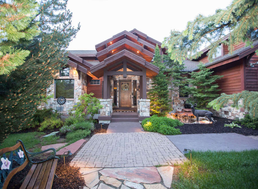 This stunning home boasts a beautiful stone facade and a welcoming wooden door.