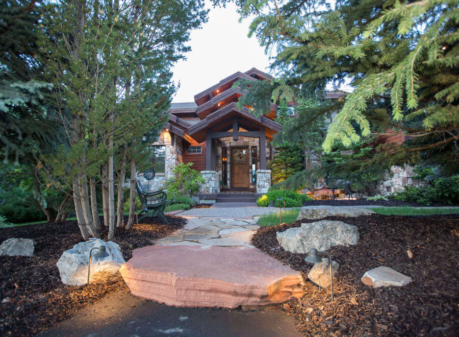 This stunning property showcases a beautiful stone pathway leading to a luxurious home.