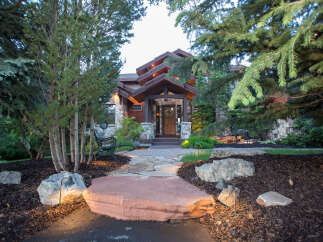This stunning property showcases a beautiful stone pathway leading to a luxurious home.