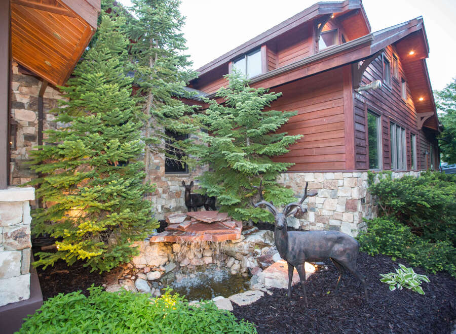 This stunning property boasts a beautiful exterior with a combination of stone and wood siding, creating a warm and inviting atmosphere.