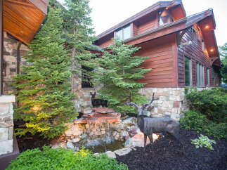 This stunning property boasts a beautiful exterior with a combination of stone and wood siding, creating a warm and inviting atmosphere.