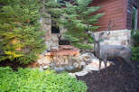 Discover a serene oasis with this stunning property, featuring a beautifully crafted water feature and lush greenery.