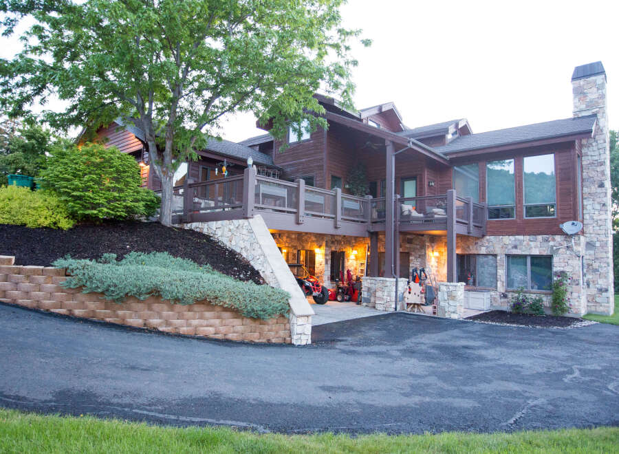 This stunning property boasts a beautiful exterior with a combination of wood and stone elements.