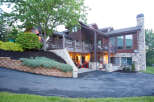 This stunning property boasts a beautiful exterior with a combination of wood and stone elements.