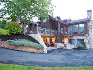 This stunning property boasts a beautiful exterior with a combination of wood and stone elements.