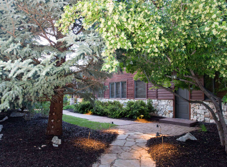 Discover the charm of this property with its inviting stone pathway leading to a beautifully designed home.